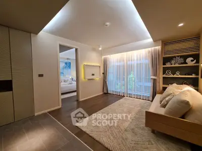 Modern living room with elegant decor and cozy ambiance, featuring a view into a stylish bedroom.