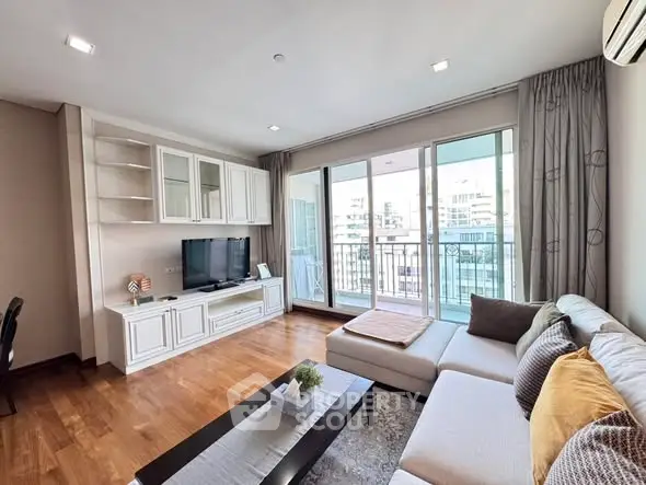 Spacious living room with modern decor and large balcony access.