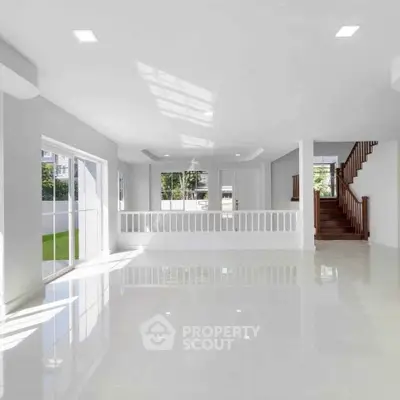 Spacious modern living room with large windows and glossy floors, perfect for natural light lovers.