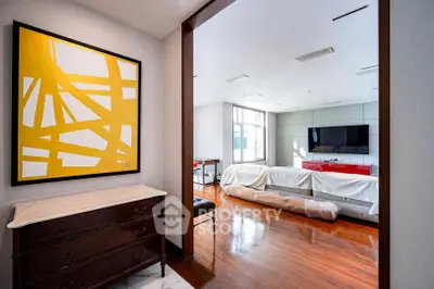 Spacious living room with modern art and wooden flooring, perfect for stylish living.