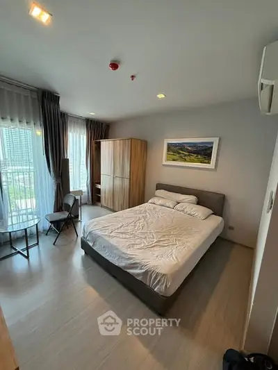 Modern bedroom with large windows and stylish decor in a high-rise apartment.