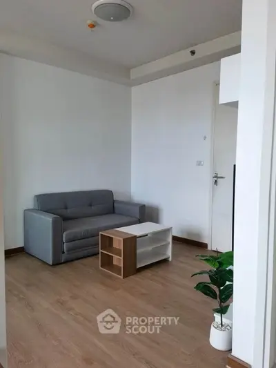 Modern minimalist living room with grey sofa and wooden coffee table