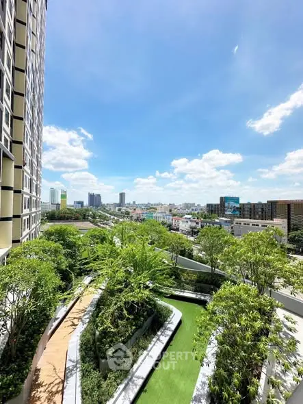 Stunning urban view from a high-rise building with lush green garden terrace.