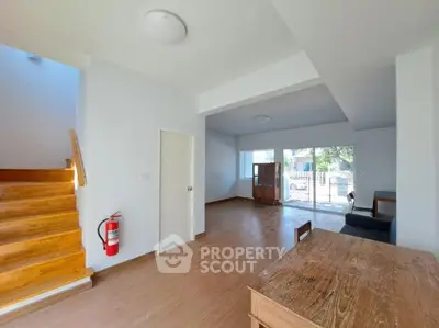 Spacious open-plan living area with wooden floors and natural light.