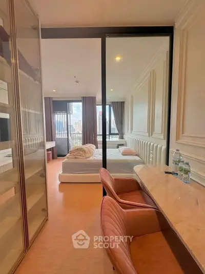 Modern bedroom with city view, featuring elegant decor and cozy workspace.