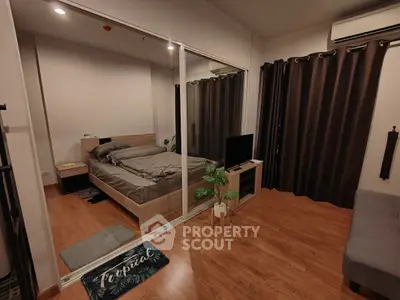 Cozy bedroom with wooden flooring, mirrored closet, and modern decor in a stylish apartment.