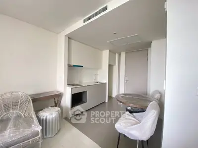 Modern minimalist kitchen with sleek white cabinetry and compact dining area.