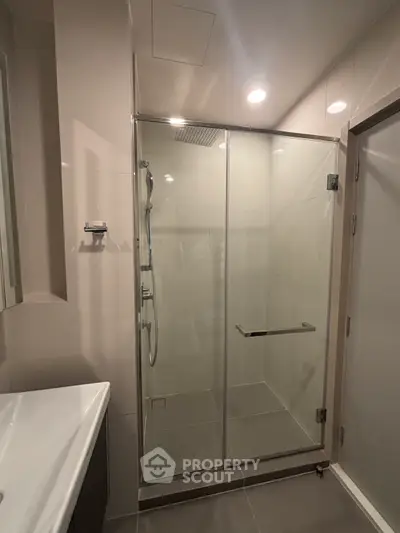 Modern bathroom with glass shower enclosure and sleek fixtures