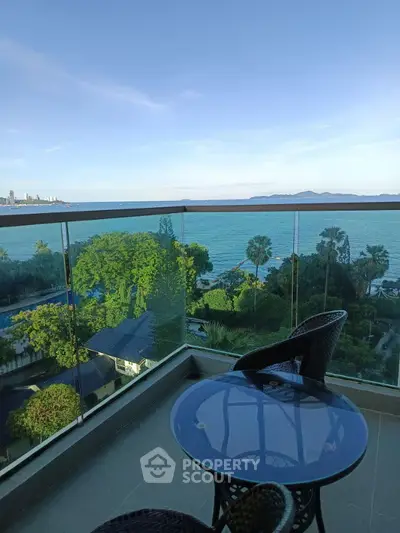 Stunning balcony view overlooking ocean and lush greenery, perfect for relaxation.
