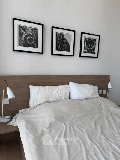 Modern bedroom with stylish decor and framed art above a cozy bed, perfect for relaxation.