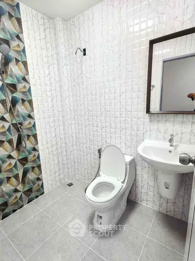 Modern bathroom with geometric tile design and sleek fixtures