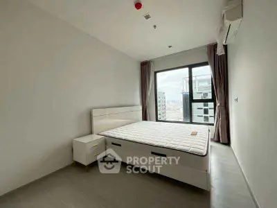 Modern minimalist bedroom with large window and city view