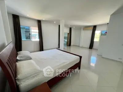 Spacious bedroom with modern design and large windows for natural light.