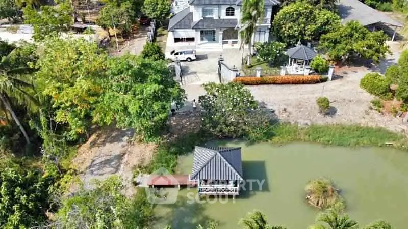 Charming lakeside property with gazebo and lush greenery, perfect for tranquil living.