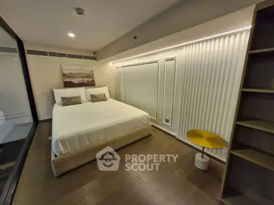 Modern bedroom with elegant lighting and stylish decor, featuring a cozy bed and wooden flooring.