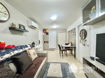 Cozy living room with modern decor and dining area, featuring neutral tones and stylish furnishings.