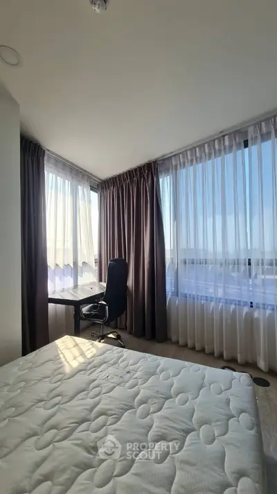 Bright bedroom with large windows and modern furnishings