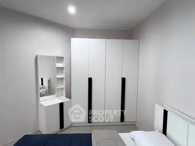 Modern bedroom with sleek white wardrobe and stylish vanity in a cozy setting.