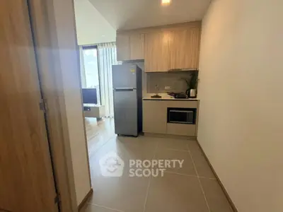 Modern kitchen with sleek appliances and wooden cabinetry in a stylish apartment.