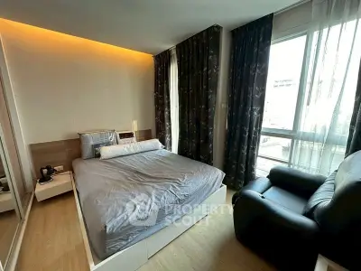 Modern bedroom with large window and cozy seating area