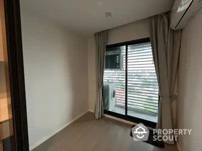 Modern apartment room with balcony and city view, featuring sleek flooring and air conditioning.