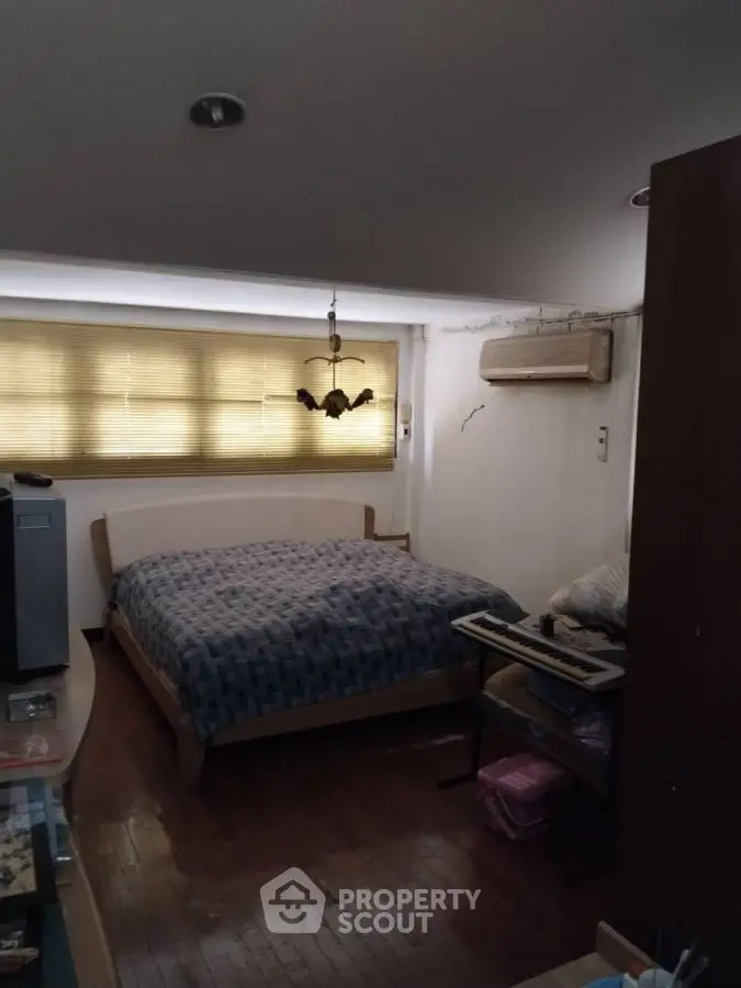 Cozy bedroom with wooden flooring and air conditioning, perfect for restful nights.