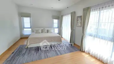Spacious bedroom with large windows and elegant decor in modern home