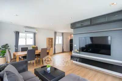 Spacious modern living room with large TV and dining area, perfect for family gatherings.