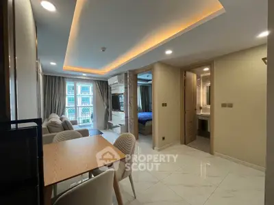 Modern apartment interior with open layout, featuring dining area and view into bedroom.