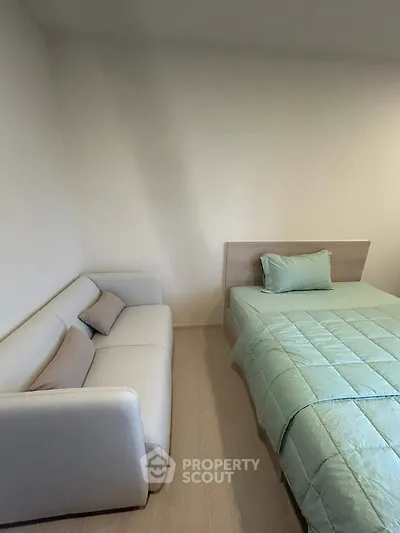 Cozy bedroom with modern bed and comfortable sofa, perfect for relaxation.