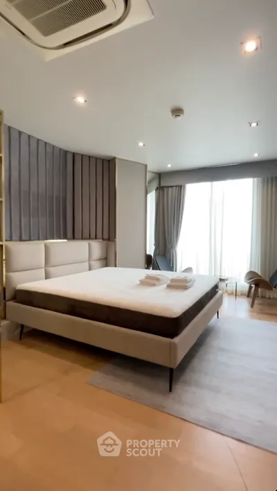 Luxurious modern bedroom with elegant decor and large windows for natural light.