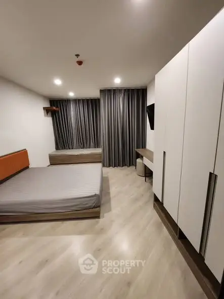 Modern bedroom with sleek design, featuring a large bed, stylish wardrobe, and elegant curtains.