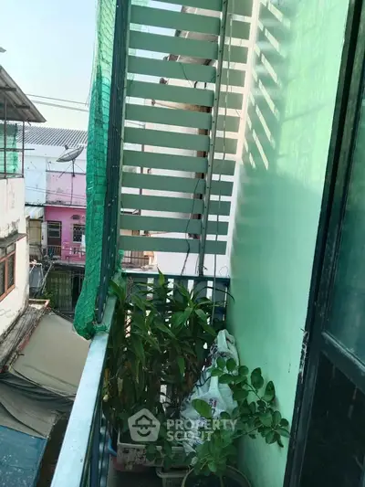 Charming small balcony with lush plants and urban view