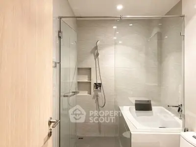 Modern bathroom with glass shower and sleek fixtures in a contemporary apartment.