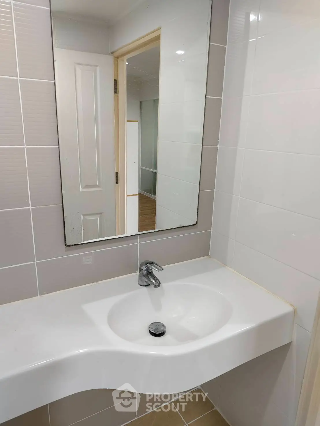 Modern bathroom with sleek sink and large mirror in a contemporary home.