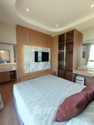 Modern bedroom with stylish decor and built-in wardrobe, featuring a mounted TV and elegant lighting.