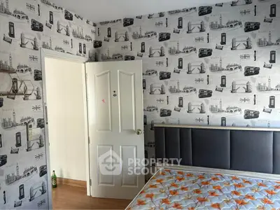 Charming bedroom with unique wallpaper and cozy bed setup.