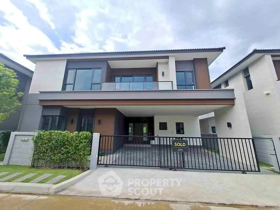 Modern two-story house with sleek design and spacious driveway in a serene neighborhood.