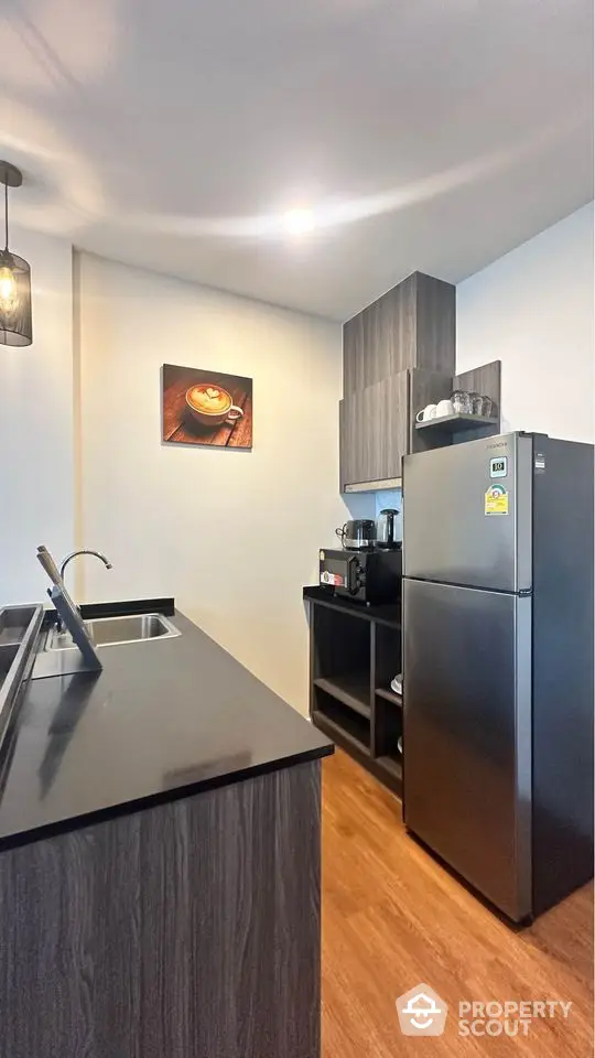 Modern kitchen with sleek design, featuring a stainless steel fridge and stylish cabinetry.