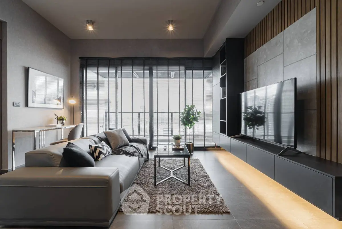 Luxurious modern living room with sleek design and large TV, featuring floor-to-ceiling windows and stylish decor.