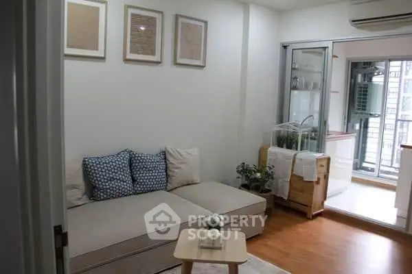 Cozy living room with modern decor and balcony access in a stylish apartment.