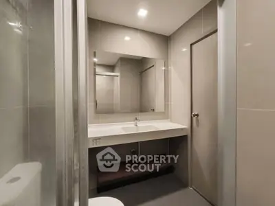 Modern bathroom with sleek design and large mirror in a contemporary apartment.