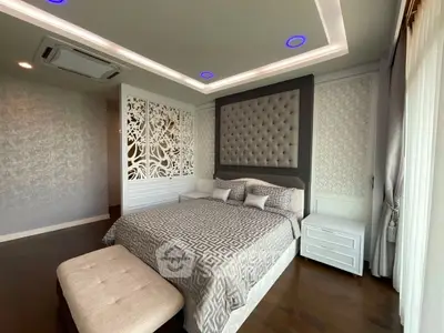 Luxurious bedroom with elegant decor and modern lighting in a stylish apartment.