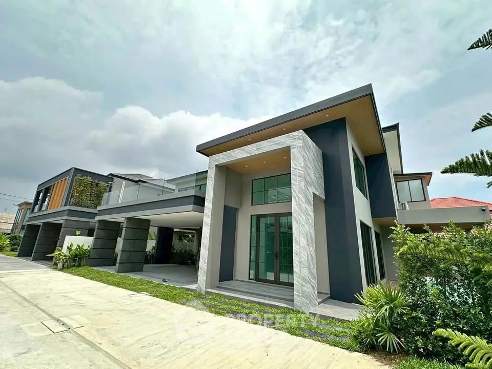 Modern luxury home with sleek design and spacious driveway, featuring large windows and lush landscaping.