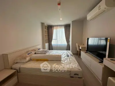 Spacious bedroom with modern furnishings and natural light in a stylish apartment.
