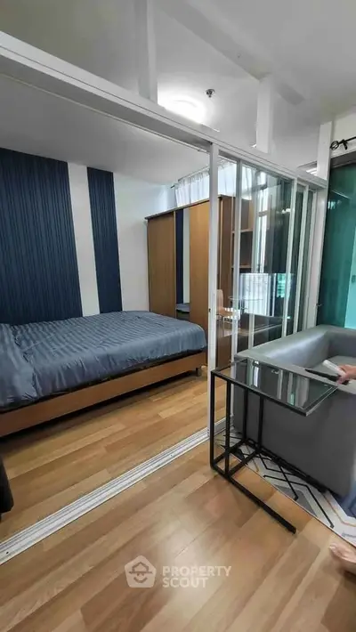 Modern bedroom with glass partition and stylish decor in a contemporary apartment.