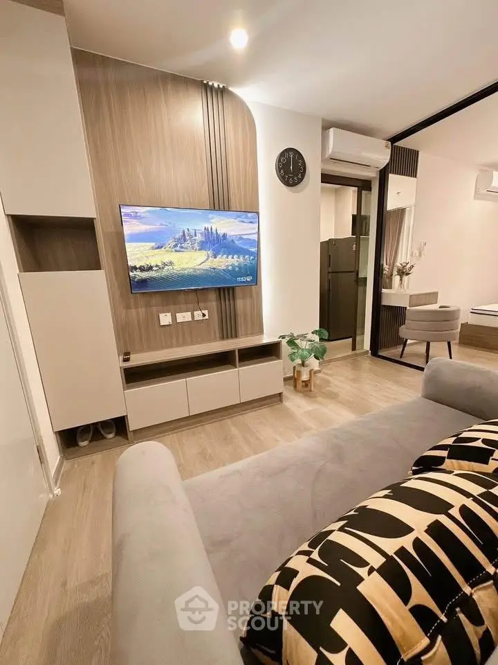 Modern living room with stylish decor and wall-mounted TV in a cozy apartment.
