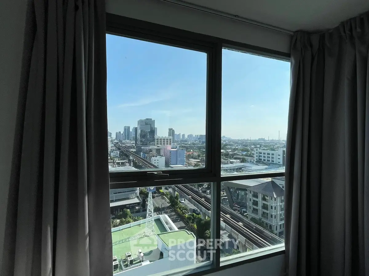 Stunning city view from high-rise apartment window with curtains