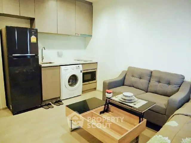 Modern apartment interior with kitchen and living area featuring sleek appliances and cozy furniture.