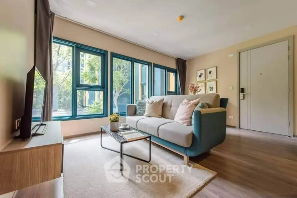 Spacious living room with modern decor and large windows offering a serene garden view.